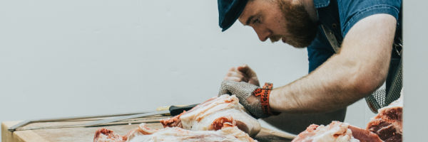 boucher qui découpe sa viande