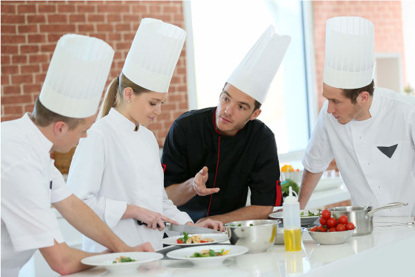 chefs cuisiniers autour d'un plat