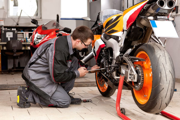 apprentis mécanicien moto travaillant sur une moto