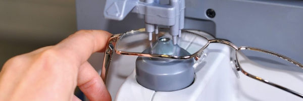 opticien ajoutant des verres sur une monture