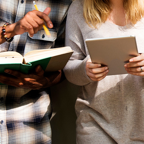 deux personnes avec un livre et une tablette