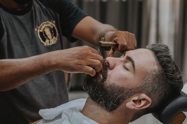 un homme se fait raser chez le barbier