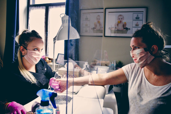 femme avec une cliente portant des gants dans un salon de beauté