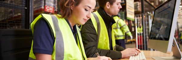 Staff managing warehouse logistics in an on-site office Staff managing warehouse logistics in an on-site office
