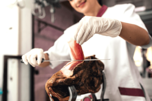 Charcutière qui coupe du jambon