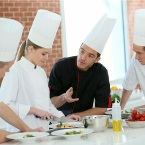 chefs cuisiniers autour d'un plat