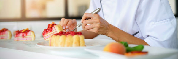 chef qui dresse un dessert dans une assiette