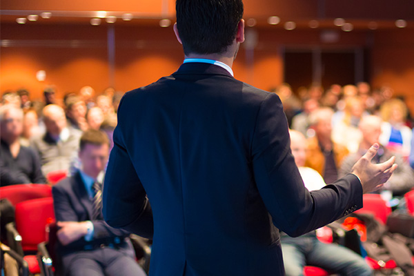 homme qui tiens une conférence