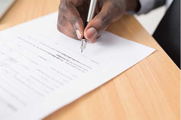 homme signant un contrat d'assurance