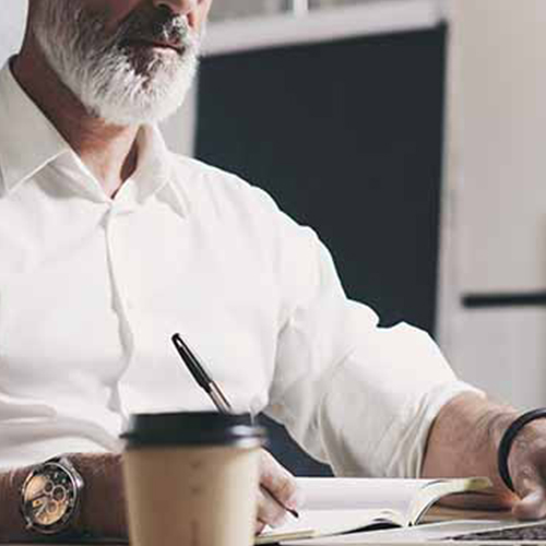 homme qui travaille sur son bureau avec un café