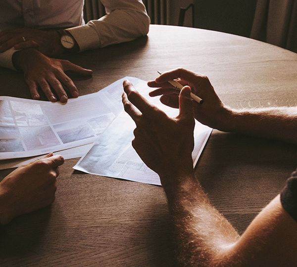 personnes qui travaillent autour d'une table avec un stylo