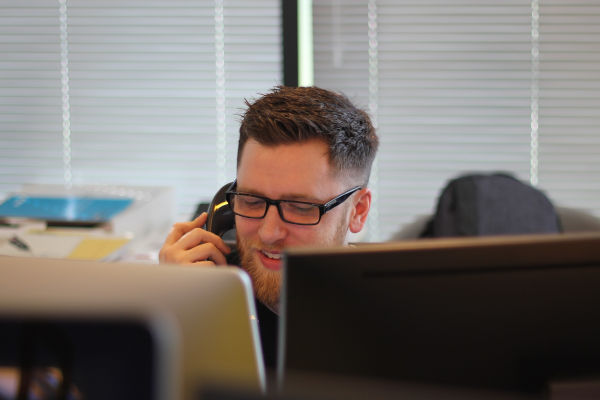 homme derrière un bureau qui parle au téléphone