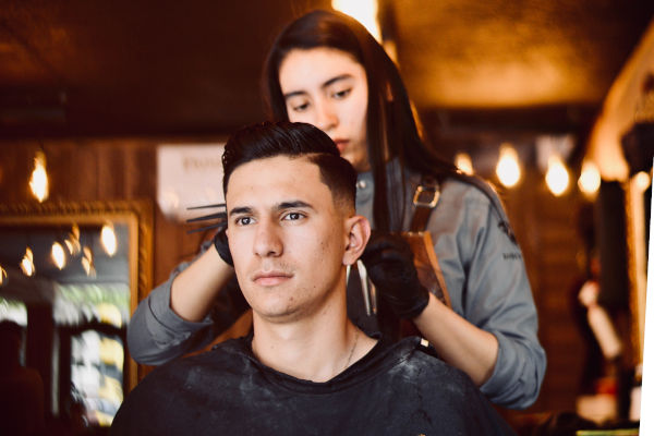 coiffeuse coiffant un homme