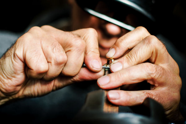 un bijoutier travaille une bague