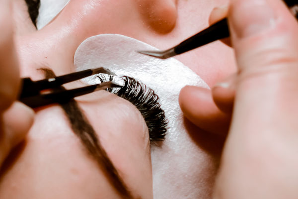 une femme qui se fait poser des extensions de cils