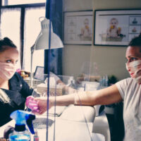 femme avec une cliente portant des gants dans un salon de beauté