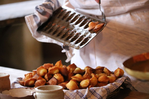 pâtissier qui démoule des madeleines du moule