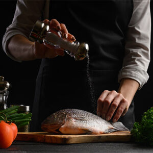 personne cuisinant un poisson