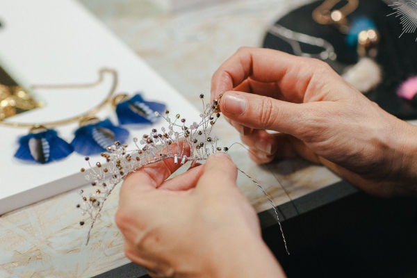 artisane qui fabrique une couronne en bijoux