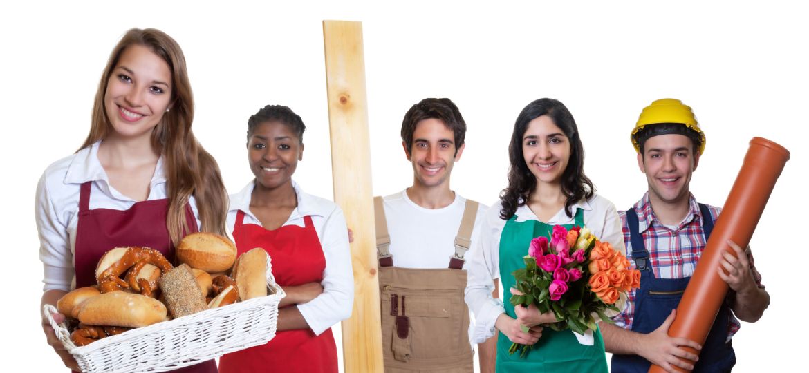 Lachende Bäckereiverkäuferin zweigt Daumen mit anderen Azubis