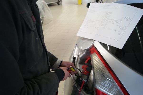 Homme qui recherche des pannes électriques sur la voiture