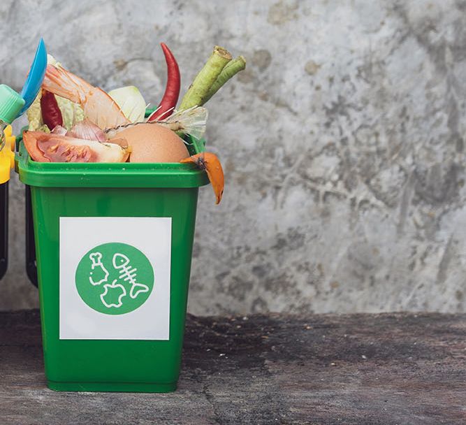 The concept of waste classification for recycling. Collection of waste bins full of different types of garbage in separation according to the color of the bin with old wall background and copy space.