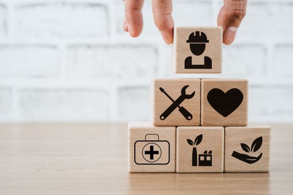 Health safety environment HSE education industry Concept, Man hand holding wooden cube block with Health safety environment icon with copy space.